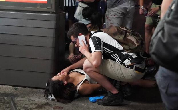 Un aficionado de la Juventus atiende a una mujer herida. 