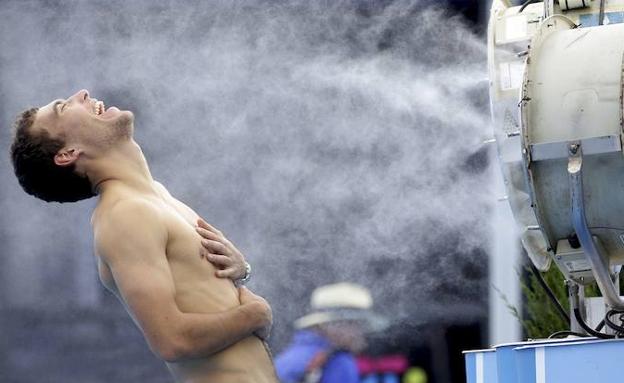 El tenista polaco Jerzy Janowicz se refresca ante un ventilador durante un partido del abierto de Australia. 