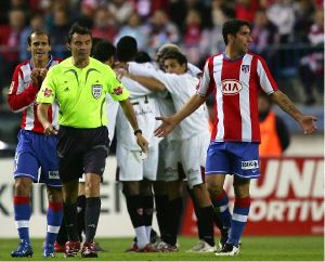 GOL. Jugadores del Atlético reclaman al árbitro langreano Enrique Mejuto. / FRANCE PRESSE