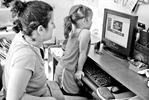 PELIGRO EN LA RED. Una niña observa un ordenador acompañado de su madre. / AP