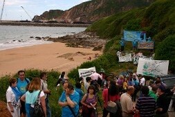 Los participantes desplegaron pancartas en la playa de Peñamaría. / P. G.-P.