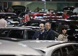 Visitantes contemplando los coches en venta en el pabellón de La Magdalena, ayer. ::                             SERGIO LÓPEZ