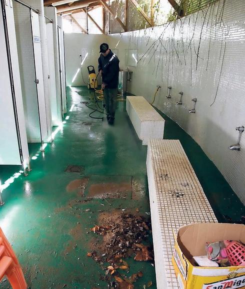 Operarios limpiando los vestuarios de la playa riosellana.