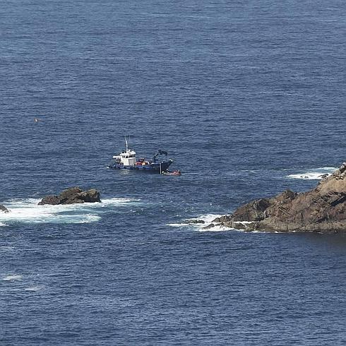 El barco 'Latero' trabaja en la reflotación del pesquero 'Santa Ana', hundido hace días junto a la isla Erbosa en el Cabo de Peñas.