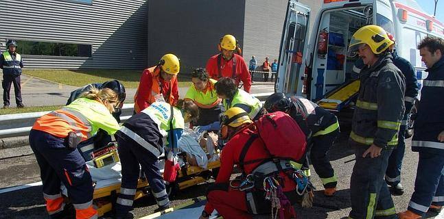 Sanitarios y bomberos se disponen a evacuar a una de las veinte personas 'afectadas' por el supuesto escape de cloro 