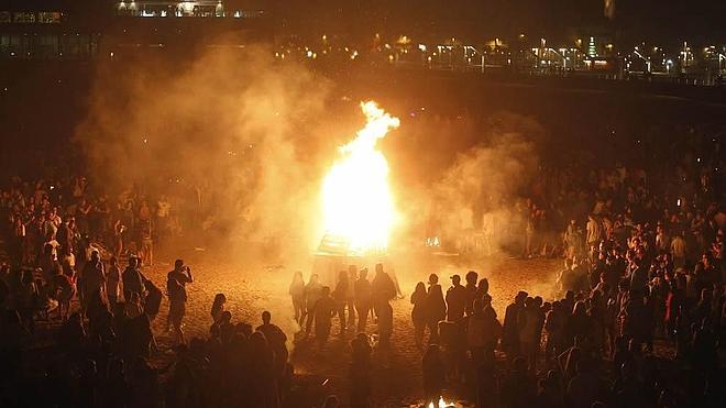A medianoche la hoguera de Poniente comenzó a arder, desafiando al orbayu. A su lado, numerosas pequeñas fogatas de los que ayer estuvieron en la playa dando la bienvenida al verano.