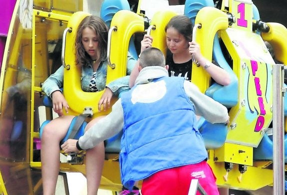 Un operario comprueba las sujeciones de una de las atracciones antes de que se ponga en marcha. 