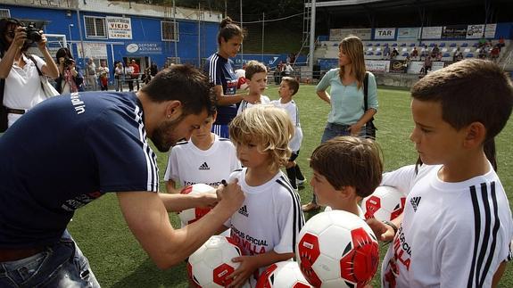 Villa firma la camiseta de uno de los niños. 