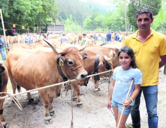 Manuel Traviesa y su hija Carlota junto a 'Guindina', la vaca gran campeona en el segmento de la raza Asturiana de Montaña. 
