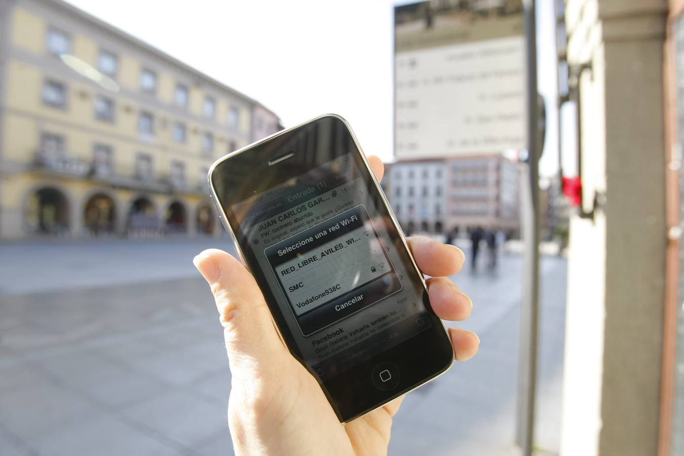 Un teléfono móvil conectado a la red wifi municipal en una calle de Avilés