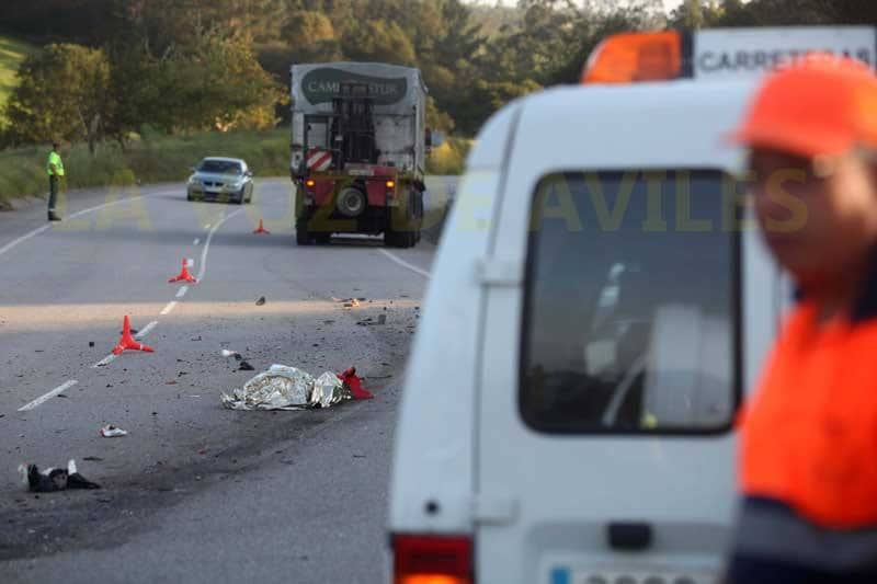 El cuerpo del motorista fallecido, tapado sobre la carretera en la que ocurrió el accidente 