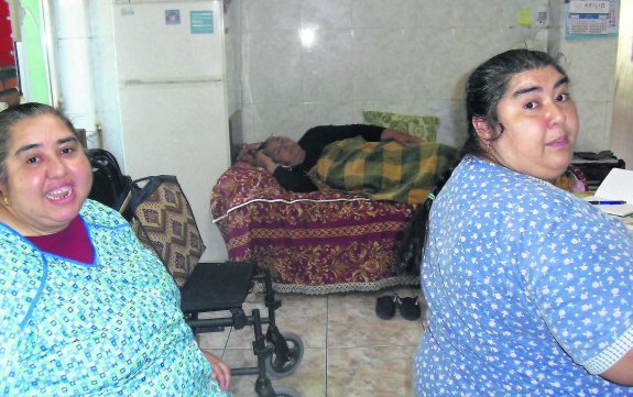 Las hermanas Herminia y Manuela Sebastiao, ayer, en la cocina de su casa, con su madre al fondo.