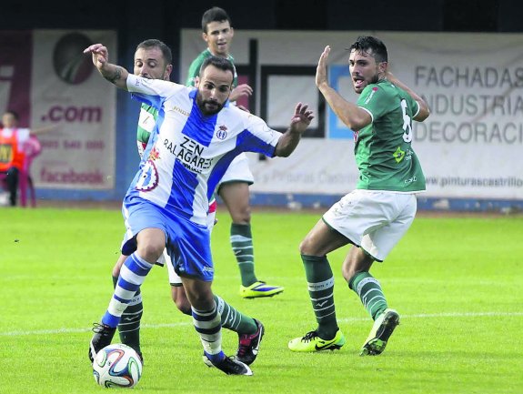 Omar Sampedro controla el balón entre dos jugadores del Coruxo en el último partido en el Suárez Puerta. 