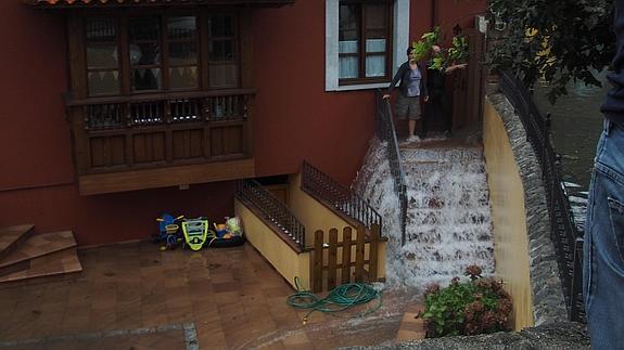 El agua arrolla por una vivienda en Llanes. 