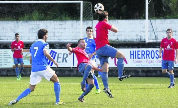 Un centrocampista del Ribadesella se lleva el balón con la cabeza en el partido frente al Juvencia. 