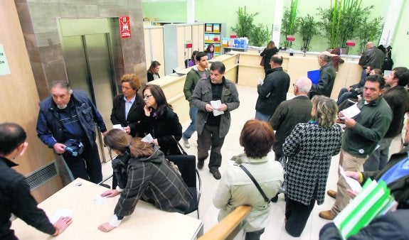 Varias personas hacen cola en la oficina de recaudación. en el centro de Oviedo. 