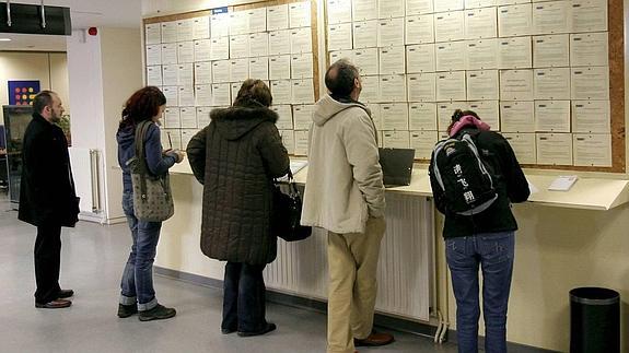 Un grupo de personas consulta ofertas de empleo en una oficina del INEM de Asturias. 