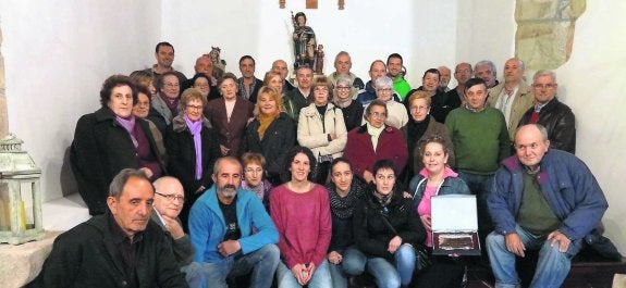 Los vecinos de Arobes en la capilla de San Roque, con la placa de Pueblo Ejemplar de Parres 2014. 