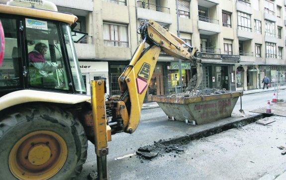 Un trabajador maneja una pala excavadora en una obra en el centro de la ciudad. 