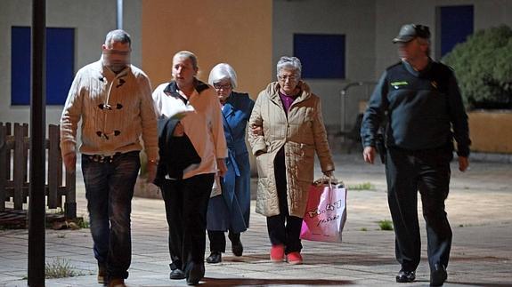 Vecinos del barrio donde se produjo el crimen, acompañados por agentes de la Guardia Civil.