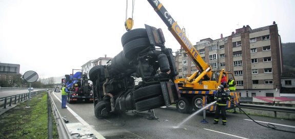 Una grúa retira el camión accidentado a primera hora de la mañana en la autovía A-66, a la altura de Pola de Lena. El accidente provocó retenciones. 