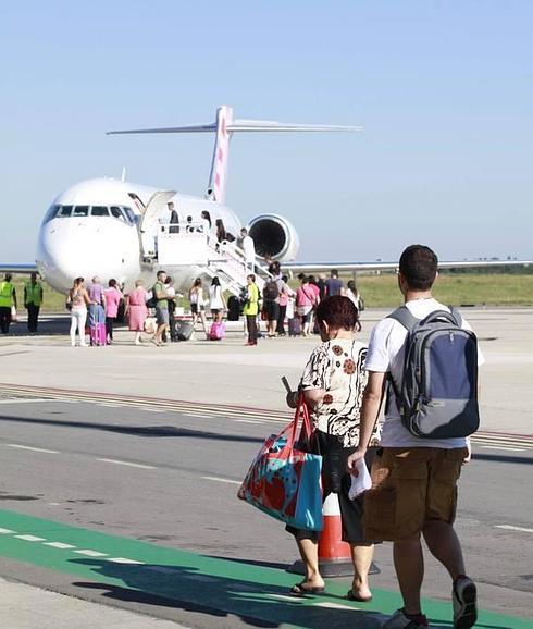 Un grupo de pasajeros se dispone a coger un avión de Volotea en el aeropuerto de Asturias. 