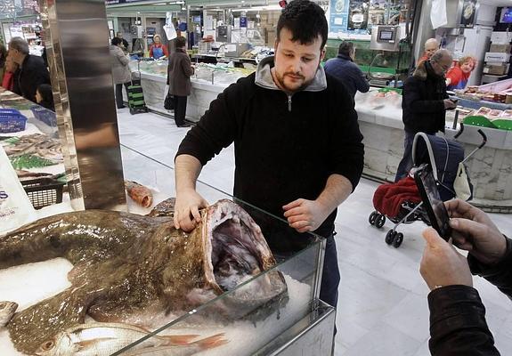 El pescadero muestra el espectacular pixín en su puesto de venta.