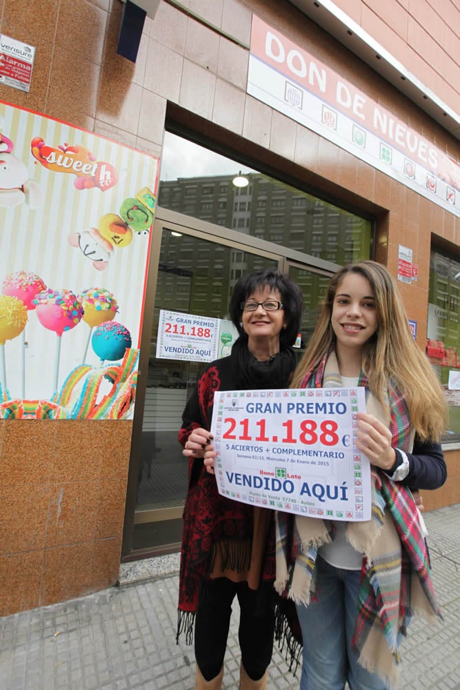 Nieves Varela y su hija, Natalia Vega, muestran el certificado del premio frente al punto de venta de la calle Fernando Morán, 2. 