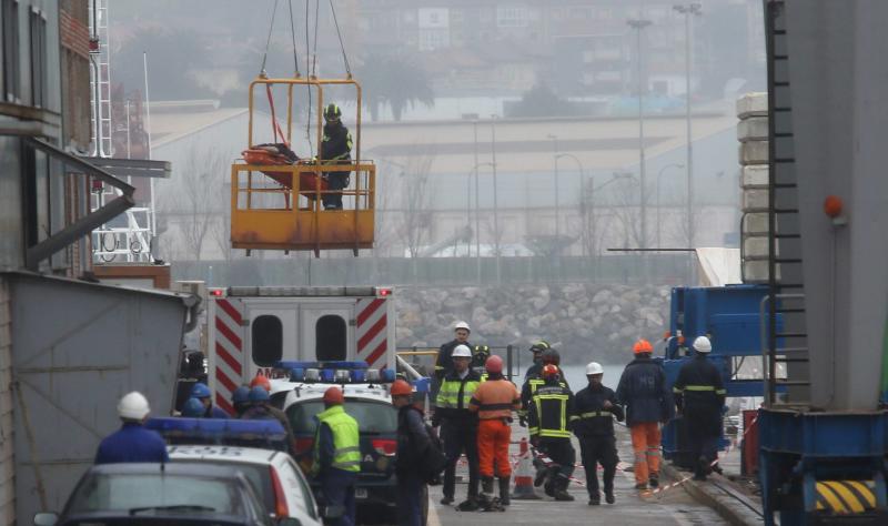 Un bombero desciende en una cesta de rescate con el cadáver.