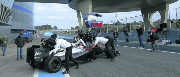 Mecánicos del equipo McLaren empujan el monoplaza de Button hacia el garaje del equipo en Jerez. 