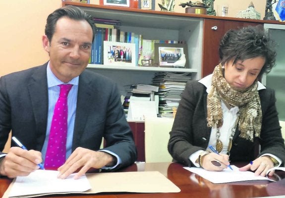 Ricard Gil y María Fernández, firmando, ayer, el contrato del aparcamiento subterráneo de Sama. 