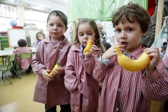 Los niños muestran un plátano de su supermercado. 