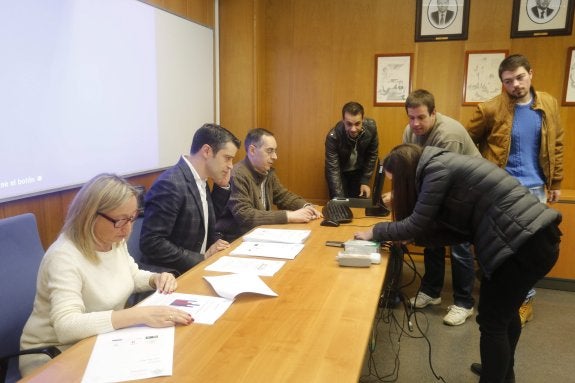 Belén Fernández, Juan Carlos Campo y el subdirector de Estudiantes, Juanjo del Coz, esperan a que unos estudiantes resuelvan un problema informático antes de la presentación del informe de género. 