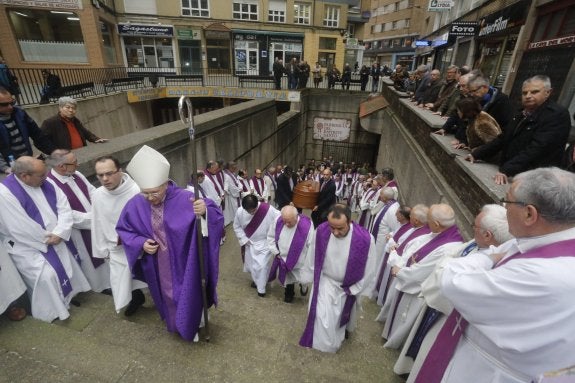 Los sacerdotes acompañan el féretro de su compañero a la salida del Espíritu Santo. 