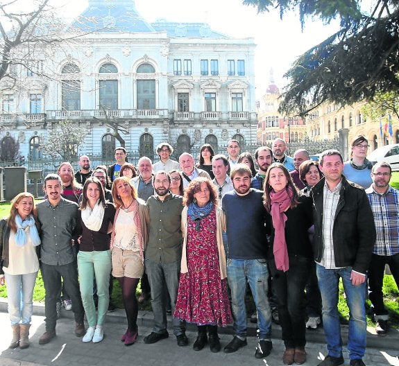 Emilio León, en el centro de la primera fila, con vaqueros y camisa oscura, junto a buena parte de la candidatura autonómica de Podemos, ayer, en Oviedo, con los edificios de la Junta General y la Presidencia del Principado a su espalda. 