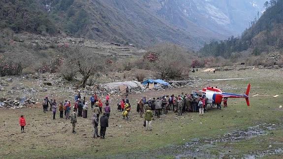 Lugareños y turistas rodean un helicóptero del Ejército nepalí en el valle de Langtang. 