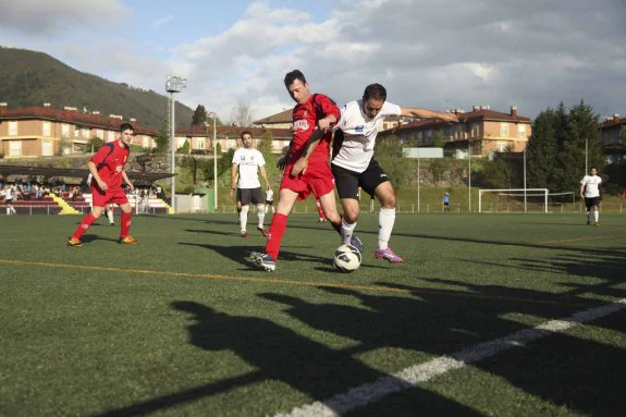Dos futbolistas del Cánicas y el Arenas disputan el esfético en el Municipal de Arriondas en el esperado derbi de la orilla del Sella. 