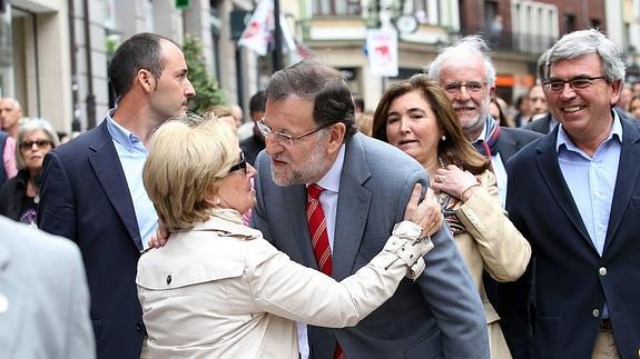 Una mujer abraza a Rajoy en su recorrido por las calles de Oviedo.