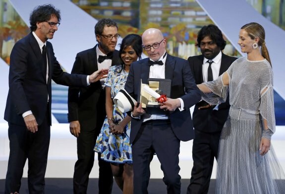 Jacques Audiard recibe la Palma de oro ante los hermanos Coen, presidentes del jurado, y los actores que protagonizan su película. 