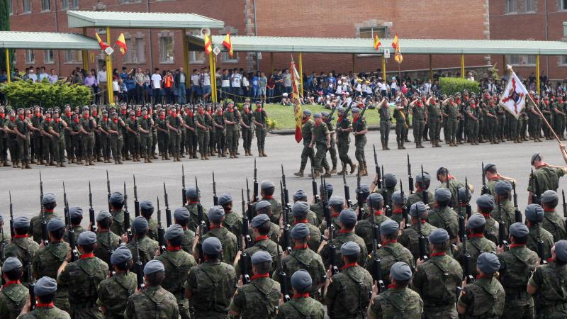 La bandera pasa frente al batallón San Quintín, al fondo, y el Toledo, en primer plano, durante los actos en el patio central. 