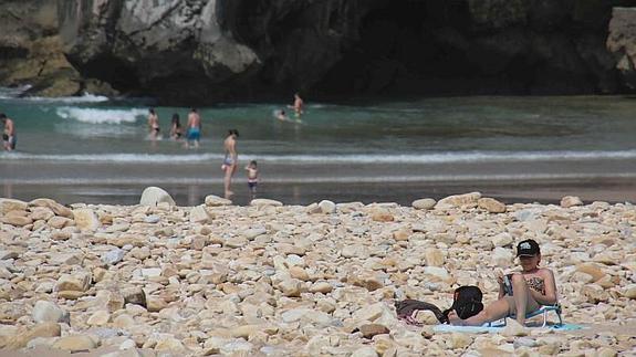 Los usuarios de la playa de Cuevas del Mar tienen que disfrutar del espacio lleno de grandes piedras.