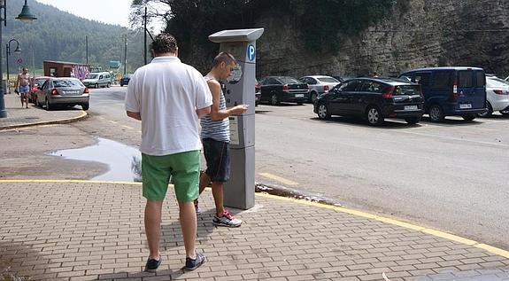 Dos usuarios, en un parquímetro instalado el pasado verano. 