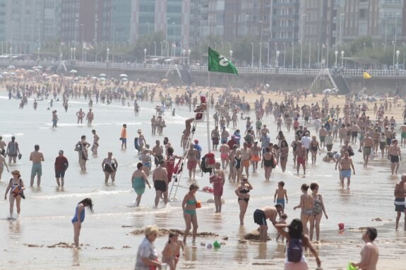 La bandera verde volvió a ondear ayer en la playa de San Lorenzo, refugio de muchos gijoneses para soportar el intenso calor. 