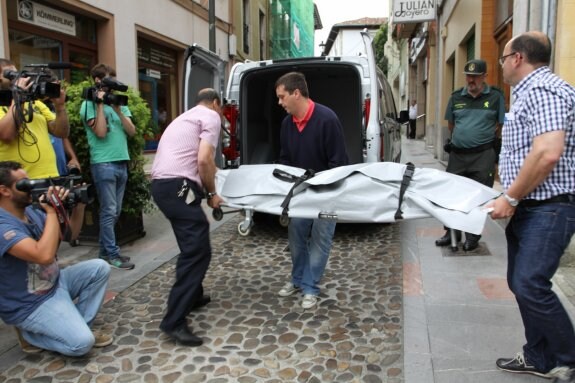 Personal de los servicios funerarios introduce uno de los cadáveres en el vehículo que los trasladó al Instituto de Medicina Legal de Oviedo. 