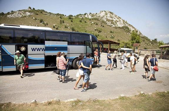 Uno de los autobuses a su llegada al aparcamiento de Buferrera, donde los turistas consultan información sobre las rutas. 