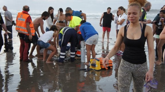 Los sanitarios atienden sobre la arena a la joven que se encuentra en estado muy grave. 