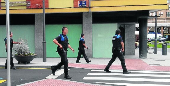 Cuatro policías locales avanzan, pistola en mano, por la calle de López Ocaña. 