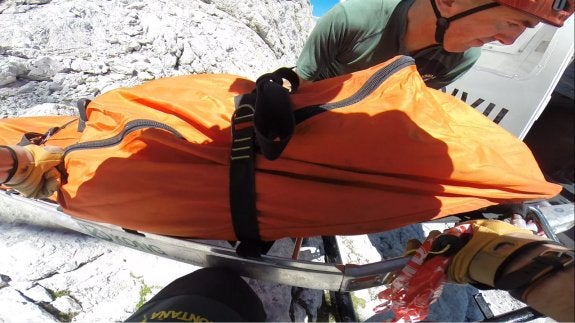 Los agentes de la Guardia Civil introducen el cuerpo en el helicóptero de la Benemérita. 