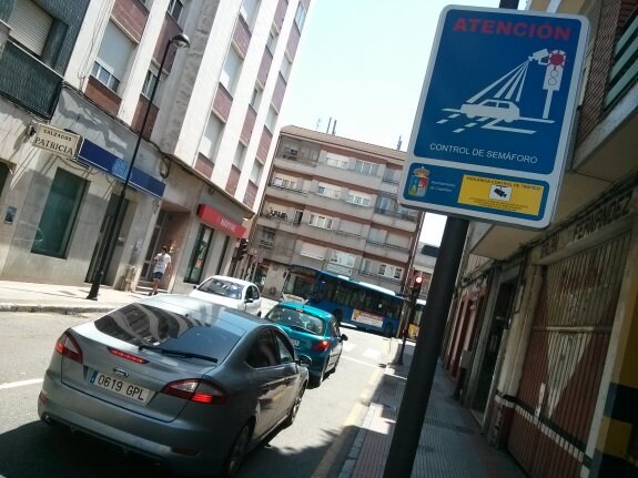 Un cartel advierte de que la intersección está vigilada por un dispositivo foto-rojo. 