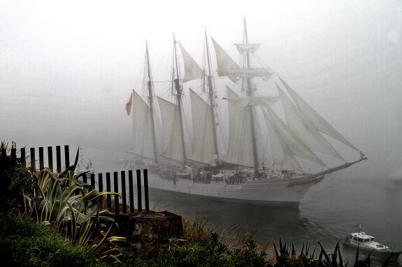 El Juan Sebastián Elcano sale del puerto de Avilés en una mañana en la que la niebla fue el acompañante inesperado. 